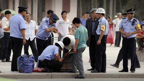 Des agents de sécurité chinois fouillent un homme d'origine ouïghour à Kashgar.