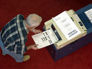 Un �lecteur de l'Iowa glisse son bulletin de vote dans un lecteur optique lors du scrutin de 2000.