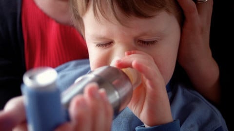 Un enfant souffrant d'asthme utilise un inhalateur.