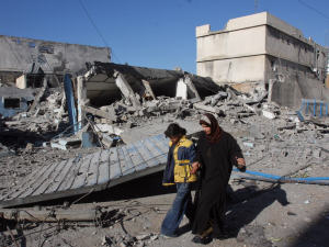 Une Palestinienne et sa fille passent devant les décombres d'un immeuble détruit par les bombardements israéliens.