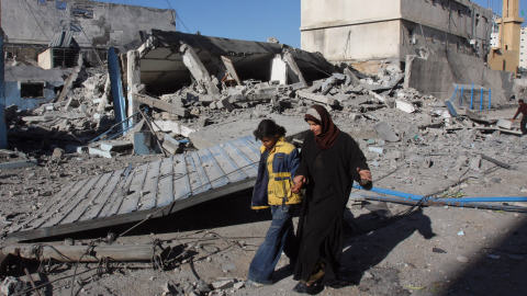 Une Palestinienne et sa fille passent devant les décombres d'un immeuble détruit par les bombardements israéliens.