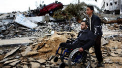Des Palestiniens tentent de se frayer un chemin parmi les édifices en ruine à Jabaliya
