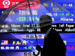 Un investisseur devant un tableau de données électroniques, vendredi, à Tokyo.