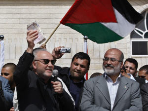 George Galloway brandit de l'argent qu'il remettra ensuite au ministre de l'Économie du gouvernement du Hamas, Ziad Al-Zaza, à Gaza, mardi.
