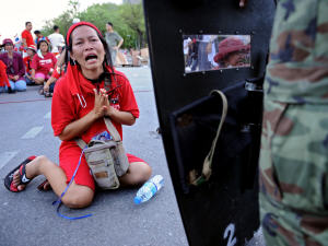 Une manifestante à genou devant un soldat à Bangkok en Thaïlande