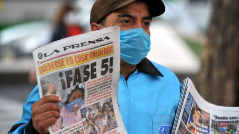 Vendeur de journaux, prot�g� par un masque, � Mexico.