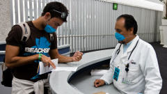 Un touriste et un médecin portent un masque à l'aéroport international de Mexico