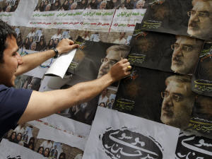 Un partisan de Mir Hossein Moussavi pose des affiches à Téhéran.