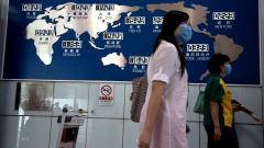 Deux Chinoises passent devant une carte des fuseaux horaires � l'a�roport de P�kin.