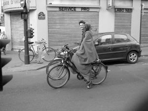 Une femme en burqa se promène à vélo dans les rues de Paris