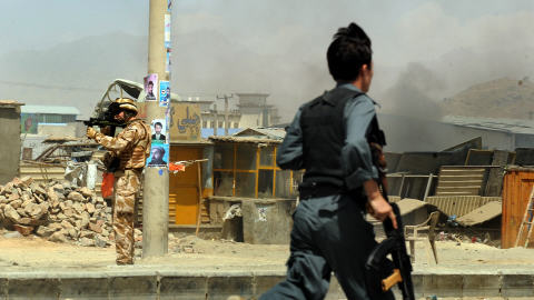 Un soldat afghan se rend sur les lieux de l'accident. En arri�re-plan, un soldat de la FIAS pointe son fusil.
