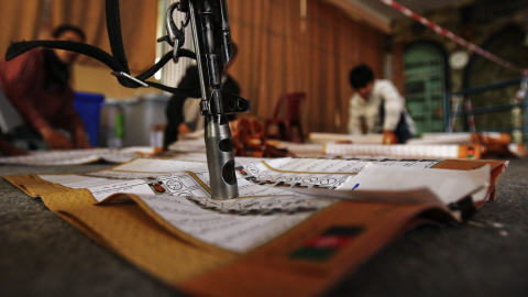 Un soldat afghan a d�pos� son arme sur un bulletin de vote lors du d�pouillement des votes, vendredi.