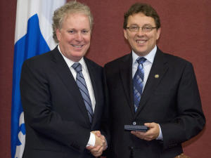 Le premier ministre Jean Charest félicite son député Jean D'amour, lors de son assermentation à l'Assemblée nationale, le 12 août.