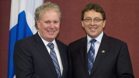 Le premier ministre Jean Charest f�licite son d�put� Jean D'amour, lors de son assermentation � l'Assembl�e nationale, le 12 ao�t.
