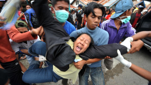 Une femme crie sa douleur apr�s avoir identifi� un proche d�c�d� dans un h�pital de Padang.