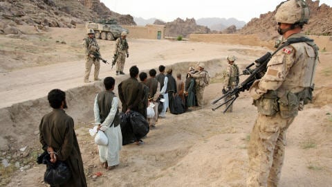 Une dizaine de prisonniers afghans sont escort�s par des soldats canadiens le 8 mai 2006.