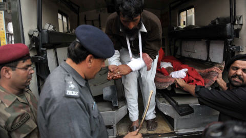 Des policiers et des volontaires transportent des bless�s.