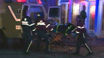 Des ambulanciers transportent les corps d�couverts.