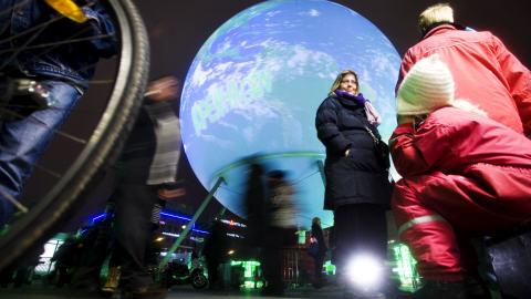 Des gens marchent devant un �norme globe terrestre sur une place de Copenhague, le 6 d�cembre 2009.