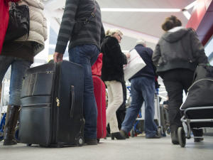 Des voyageurs attendent en ligne avec leurs bagages à l'aéroport Tegel, à Berlin.
