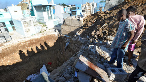 Des corps sont jet�s dans une fosse commune creus�e dans un cimeti�re de Port-au-Prince.