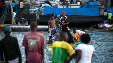 Une embarcation transporte des gens au quai Jeremie, � Port-au-Prince, qui a �t� d�truit par le tremblement de terre.