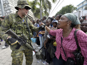 Un soldat canadien discute avec les Haïtiens qui se massent devant l'ambassade canadienne.