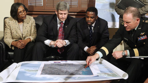 Stephen Harper �coute un expos� du chef d'�tat-major Walt Natynczyk en compagnie de repr�sentants de la communaut� ha�tienne.