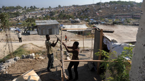 Un homme et sa soeur construisent un abri dans le quartier Caguas de Port-au-Prince.