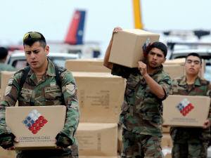 Des soldats chiliens déchargent un avion militaire d'aide humanitaire, à Concepcion.