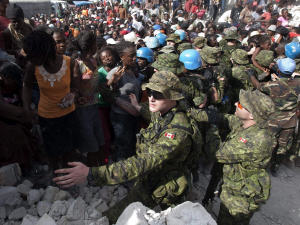 Des soldats canadiens contrôlent la foule lors d'une distribution d'aide le 22 janvier 2010, à Léogâne.