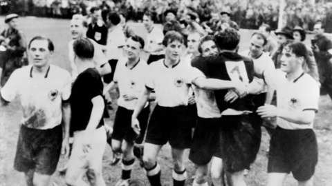L'attaquant hongrois Ferenc Puskas (2e à partir de la gauche, avec un chandail noir) félicite les joueurs allemands pour leur victoire de 3-2 en finale, le 4 juillet 1954, à Berne.