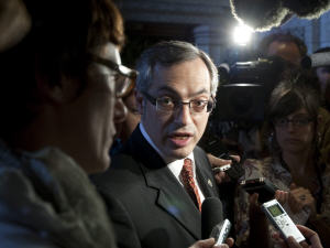 Tony Clement répond aux questions des journalistes à sa sortie des Communes jeudi.
