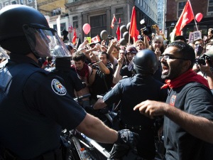 Les policiers repoussant les manifestants à Toronto.