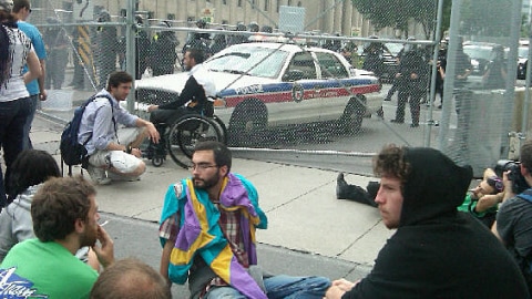 Des manifestants assis devant la cl�ture de s�curit�, malgr� l'interdiction d'en approcher � moins de cinq m�tres.