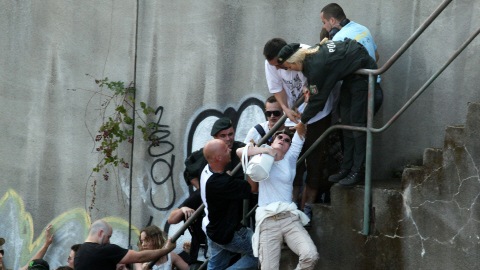 Des policiers aident une femme qui est tomb�e des escaliers lorsque la panique a saisi la foule durant la Love Parade, � Duisbourg, le 24 juillet 2010.