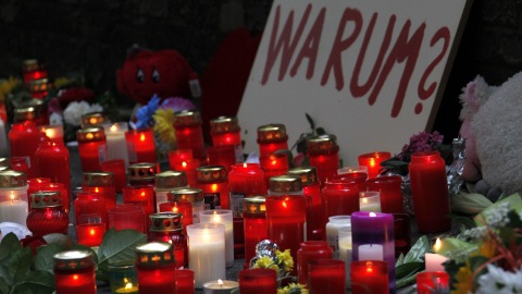 Des chandelles allum�es � la m�moire des victimes devant une affiche sur laquelle on peut lire : � Pourquoi? �