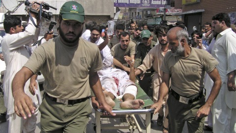 Des secouristes conduisent une personne bless�e dans l'attentat dans un h�pital de Peshawar.