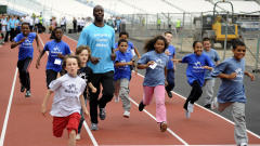 Michael Johnson teste la piste olympique avec des enfants.