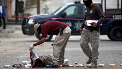 Deux policiers mexicains examinent le corps d'une femme � Ciudad Juarez. La guerre des cartels de la drogue a fait quelque 28 000 morts depuis 2006 au Mexique.