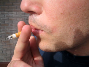 Un adolescent fume une cigarette