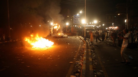 Des manifestants en col�re ont mis le feu � un v�hicule de police et une moto apr�s le triple attentat survenu � Lahore au Pakistan.