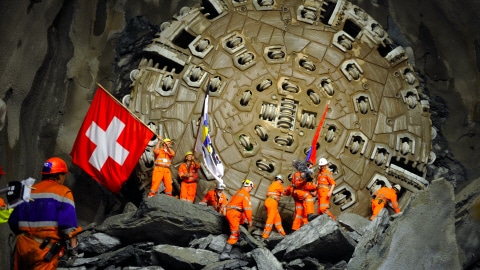 Les mineurs célèbrent, drapeau au poing, le percement du plus long tunnel ferroviaire au monde.