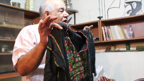 Mohamed Khatib montre une vieille robe traditionnelle palestinienne. 