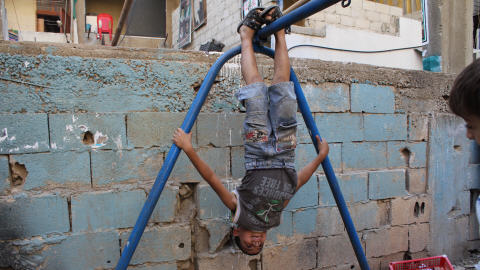 Un gamin fait des acrobaties sur la structure de la balan�oire. � Chatila, c'est l'un des rares endroits o� les enfants peuvent � jouer � autre chose que la guerre. 