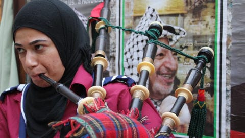 Une jeune Palestinienne, membre d'une fanfare, joue de la cornemuse � l'occasion des c�l�brations du 6e anniversaire de la mort de Yasser Arafat.