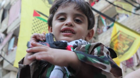 Un jeune Palestinien v�tu en militaire joue avec un pistolet en plastique lors des c�l�brations du 6e anniversaire de la mort de Yasser Arafat