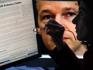 Une internaute consulte WikiLeaks. En arrière-plan, une photo du fondateur du site, Julian Assange.