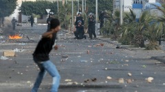Un manifestant lance des roches sur des policiers à Regueb.