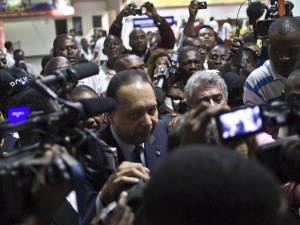 Jean-Claude Duvalier entouré de journalistes à son arrivée à l'aéroport